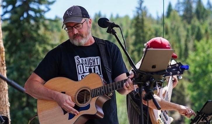 Photo: Noah Martin Photography Lance playing acoustic guitar at an outdoor show